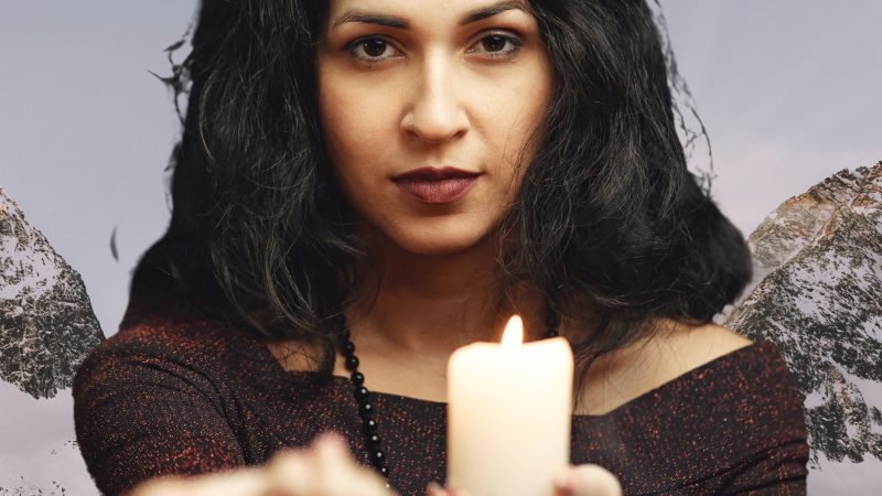An image of a female clairvoyant holding a candle illustrates a female's active role in divination.