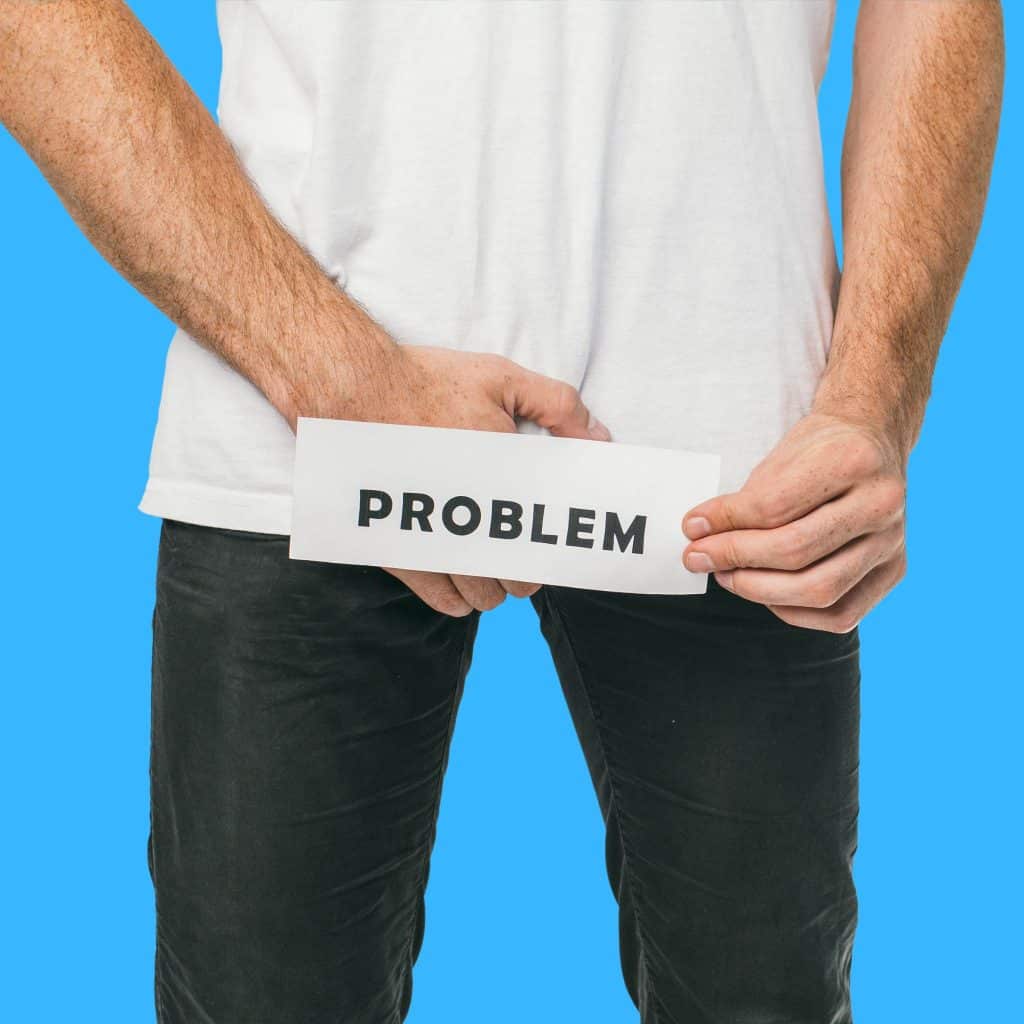 A man holding a problem sign around his dick, using the penis enlargement spell and cream, will save you from having penile problems.
