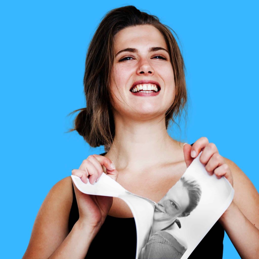 A woman tearing down a photo of her ex-lover during the casting of the break-up spells