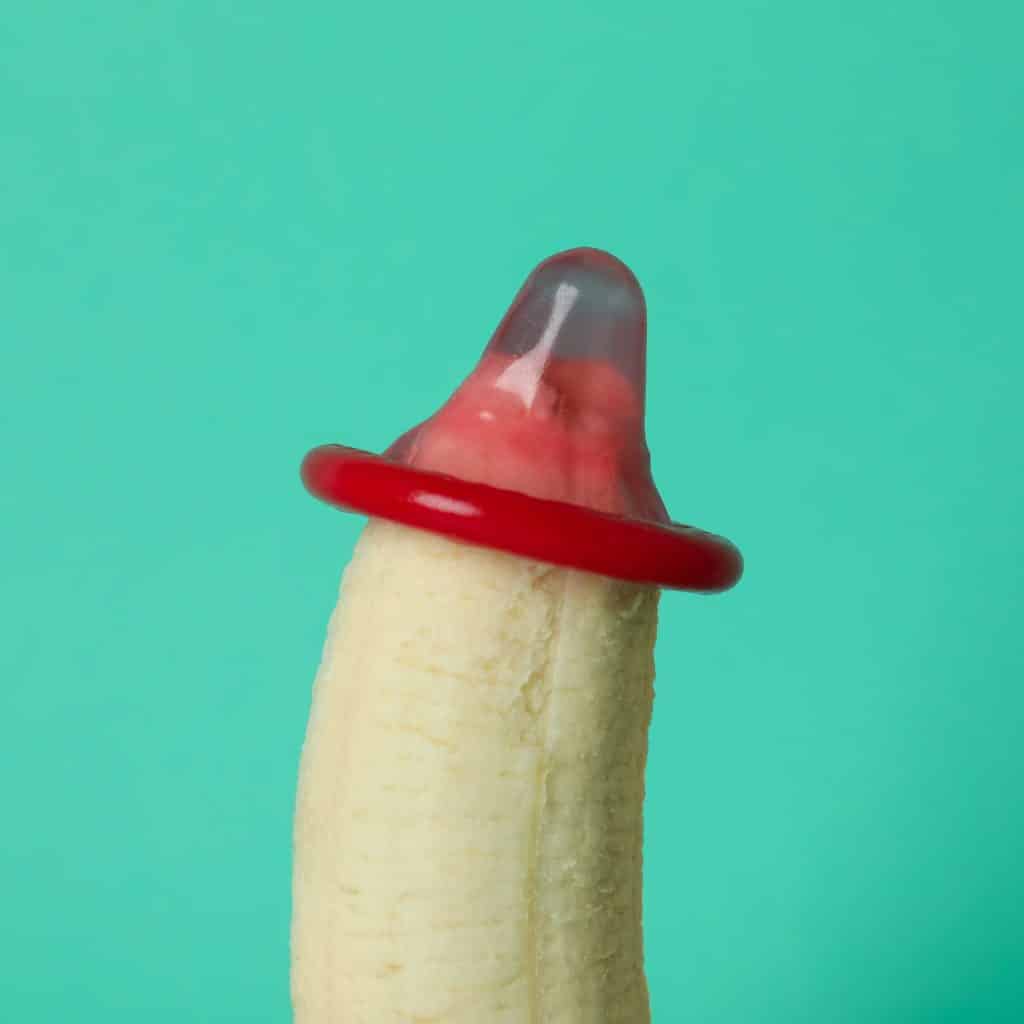 An image of a banana with a condom on its tip illustrates where to start when applying penis enlargement oil