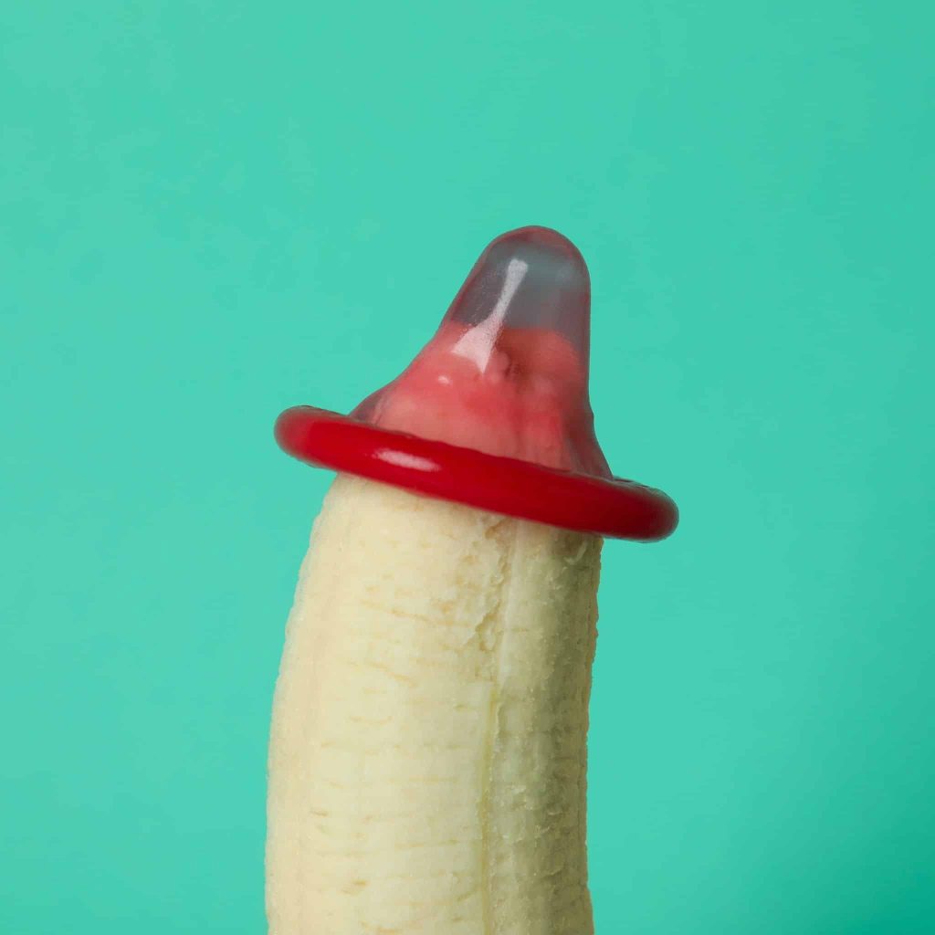 An image of a banana with a condom on its tip illustrates where to start when applying penis enlargement oil